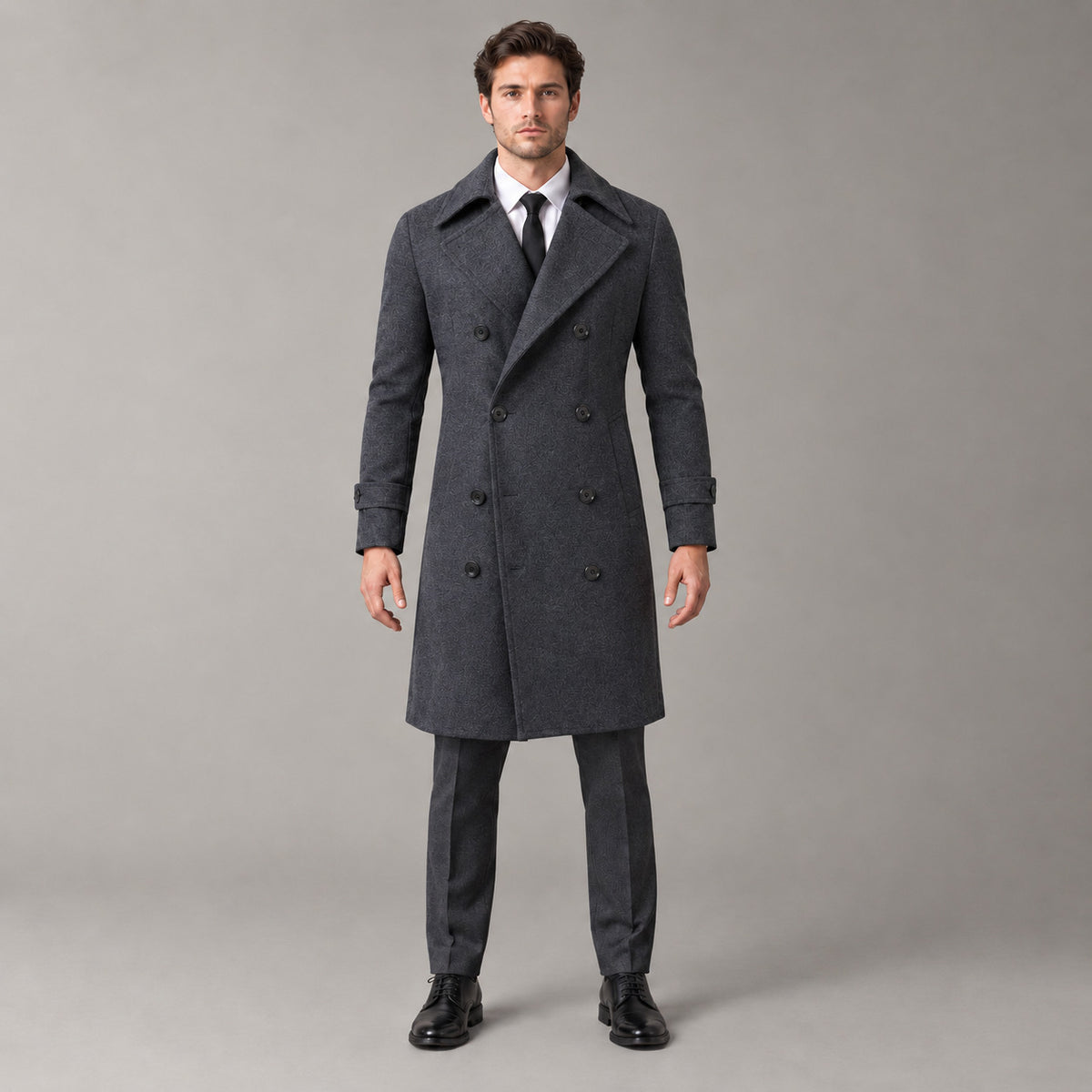 Norbury Cotton Blend Trench Coat — Dark gray double-breasted trench coat worn by a model against a pale stone studio backdrop.