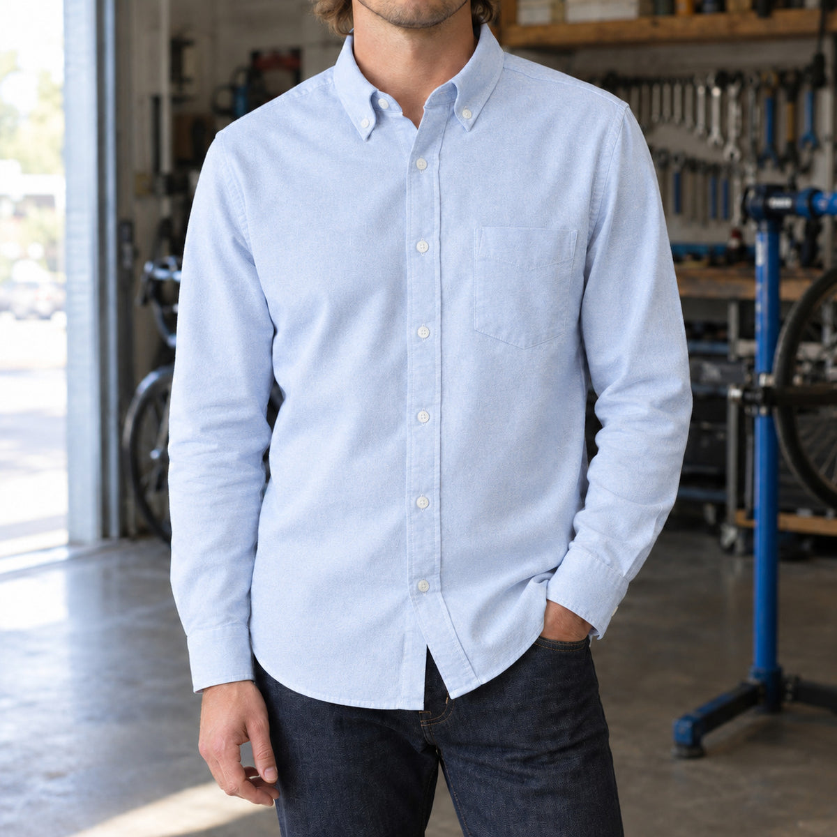Longford Cotton Oxford Shirt — Light Blue cotton oxford shirt worn by a model in a navy panelled room.