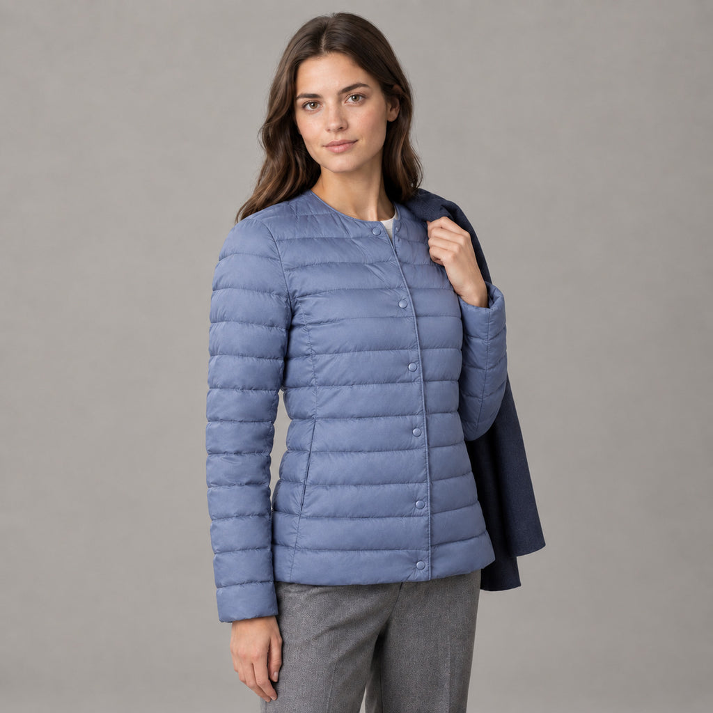 Hatherley Quilted Down Jacket — Dusty Blue collarless quilted down jacket worn by a model in a neutral studio setting.