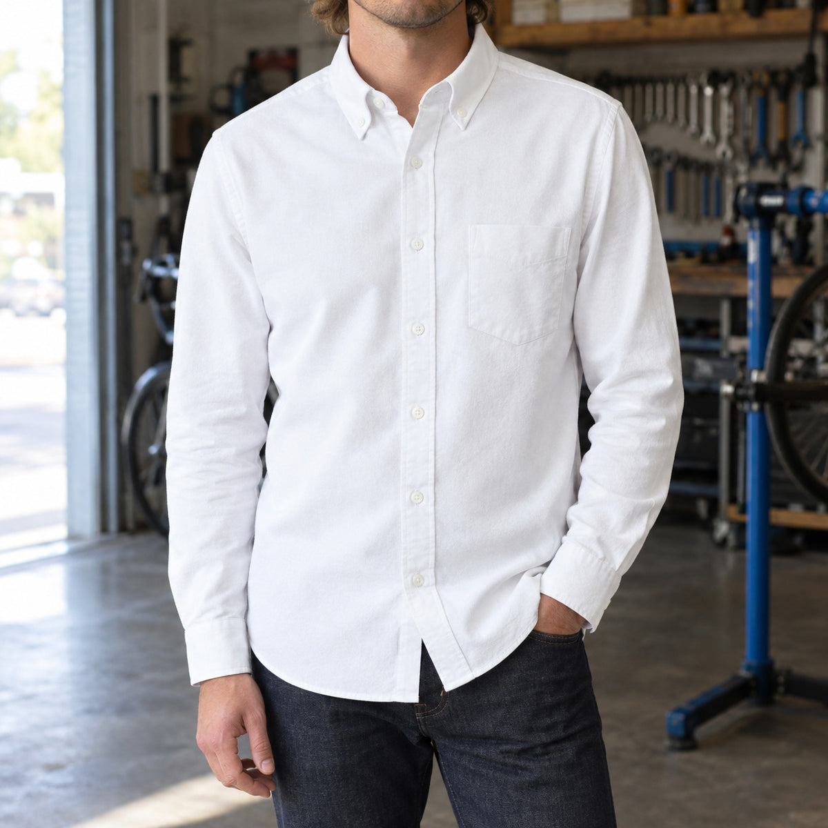 Longford Cotton Oxford Shirt — White cotton oxford shirt worn by a model in a navy panelled room.