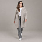 Lothian Brushed Hooded Coat — Solid heather oatmeal relaxed mid-length hooded coat worn by a model against a neutral studio backdrop.