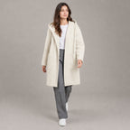 Lothian Brushed Hooded Coat — Solid soft cream relaxed mid-length hooded coat worn by a model against a neutral studio backdrop.