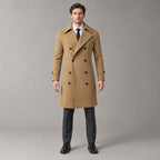 Norbury Cotton Blend Trench Coat — Camel double-breasted trench coat worn by a model against a pale stone studio backdrop.