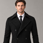 Norbury Cotton Blend Trench Coat — Black double-breasted trench coat worn, cropped from the shoulders to the waist to show the notch lapels and double-breasted buttons.