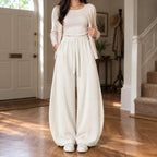 Ormsby Ribbed Wide Leg Trousers — Off-white ribbed wide-leg pants worn by a model in a lived-in panelled room.